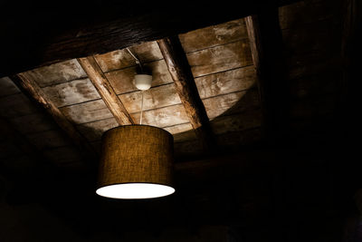 Low angle view of illuminated pendant light in building