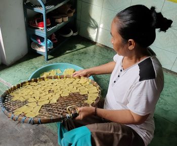 Woman holding ice cream while standing in basket