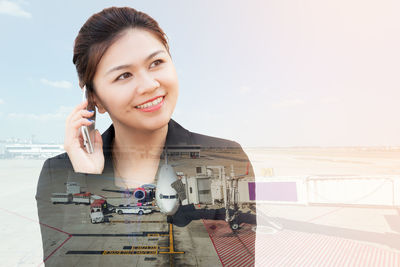 Digital composite image of woman talking on smart phone and airport