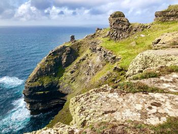 Scenic view of rocks in sea against sky