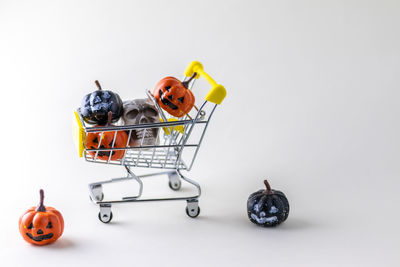 Close-up of miniature shopping cart against white background