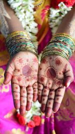 Cropped hands of bride showing henna tattoo