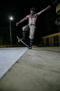 Young white man jumping on his skateboard