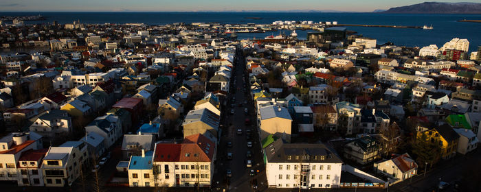 High angle view of town by sea against sky