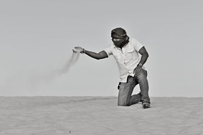 Man standing on sand against sky