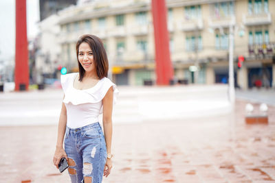 Portrait of woman standing in city during rainy season