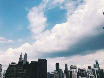 Buildings in city against cloudy sky