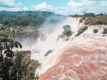 Scenic view of waterfall against sky