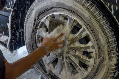 Close-up of hand cleaning car with soap sud