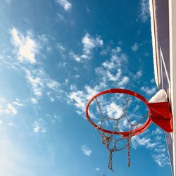 Low angle view of basketball hoop against blue sky during sunny day