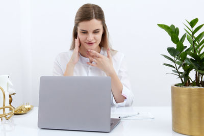 Portrait of young woman using laptop at home