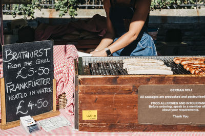 Full length of senior man for sale at market stall