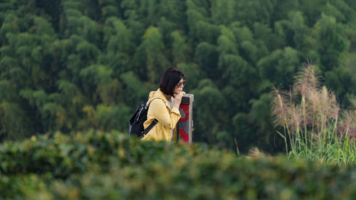 Young woman standing amidst plants