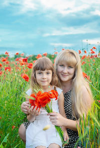 Portrait of smiling young woman standing against plants