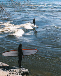 Rear view of man standing in sea
