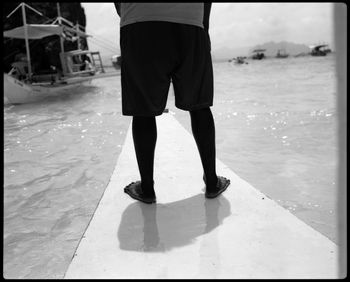 Low section of man standing in water