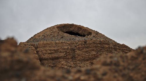 Low angle view of rock on land against sky