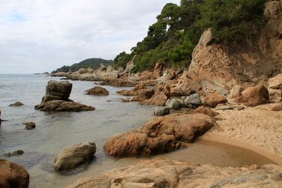 Rock formations by sea against sky