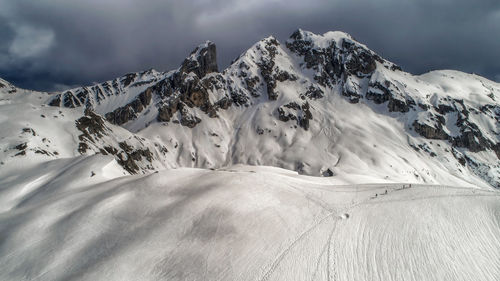 Scenic view of snowcapped mountains against cloudy sky