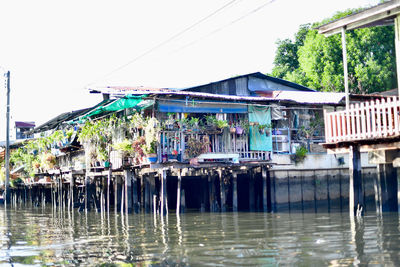 Buildings by river against sky