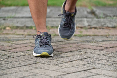 Low section of man running on footpath