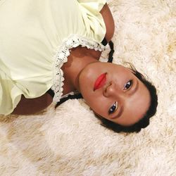 High angle portrait of woman lying on rug