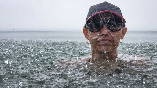 Portrait of woman swimming in sea during rainy season