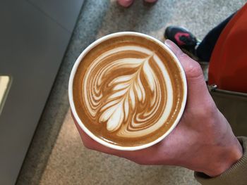 High angle view of hand holding coffee cup