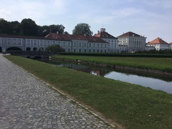 Houses by lake and buildings against sky