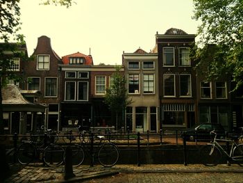 Buildings by canal against sky
