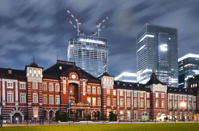 Buildings in city against cloudy sky