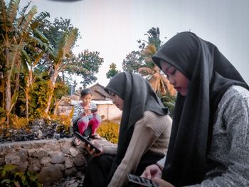 Rear view of people sitting on floor