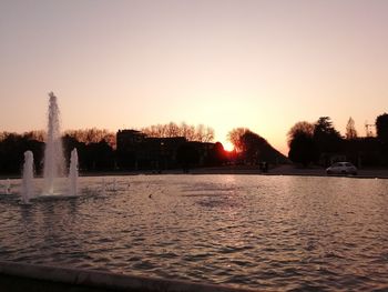 Scenic view of lake against clear sky during sunset