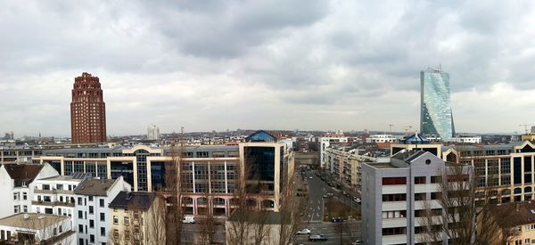 View of cityscape against cloudy sky