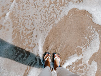 Low section of people standing on beach