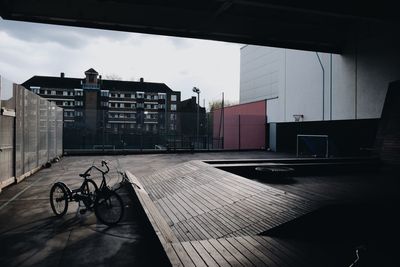 Bicycle by footpath against buildings in city