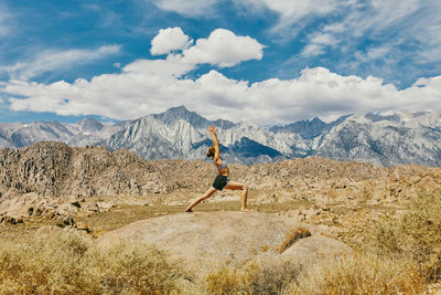 Young woman practicing yoga near alabama hills in northern california.