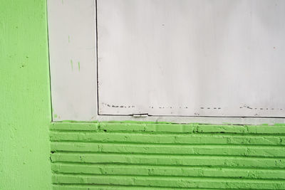 Close-up of green wall with closed door
