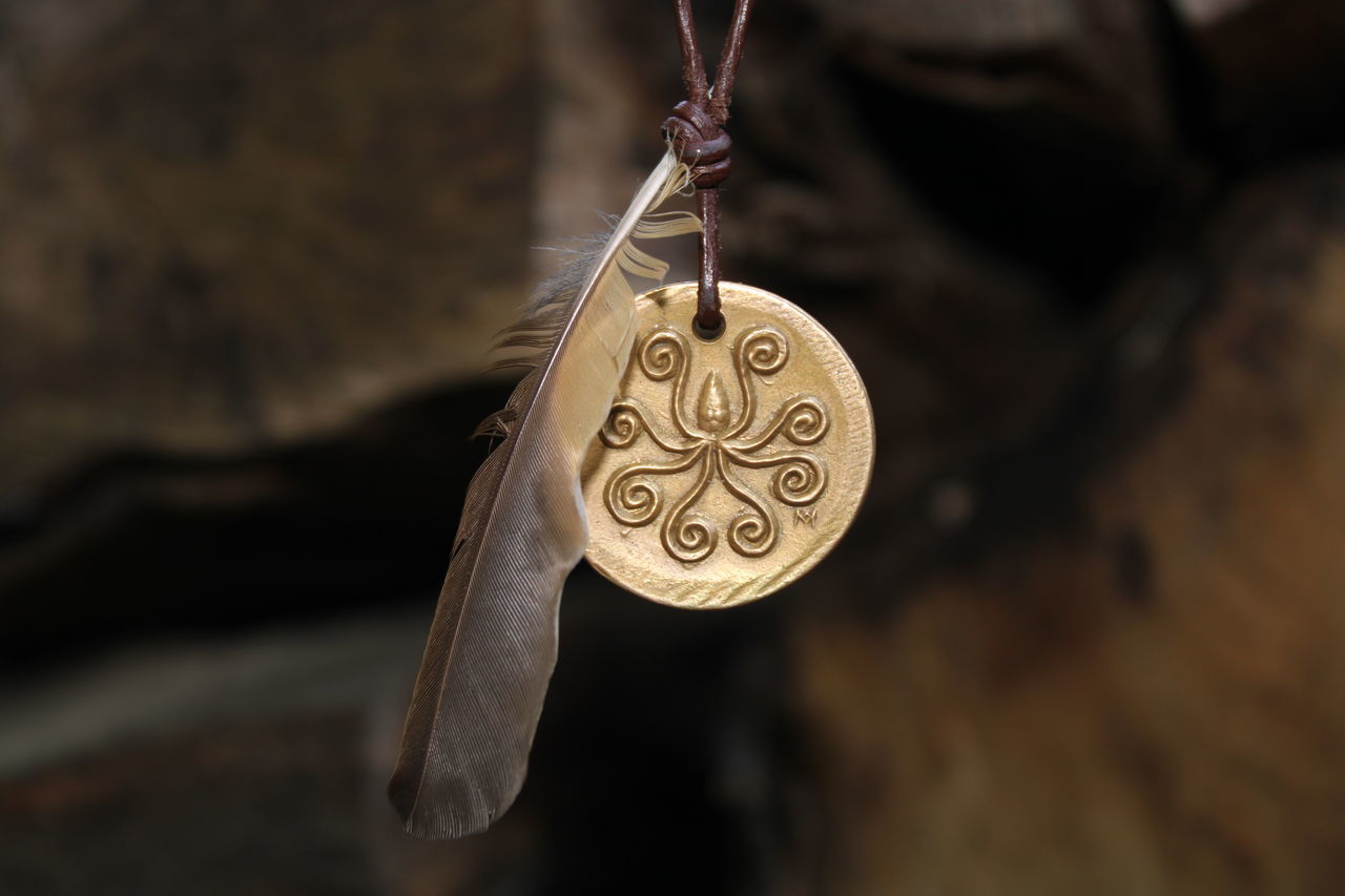 CLOSE-UP OF CROSS SHAPE HANGING ON METAL