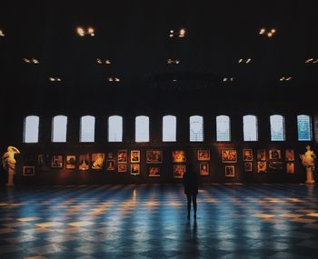 Woman standing in illuminated museum at night