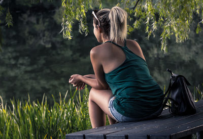 Rear view of women sitting on bench at park