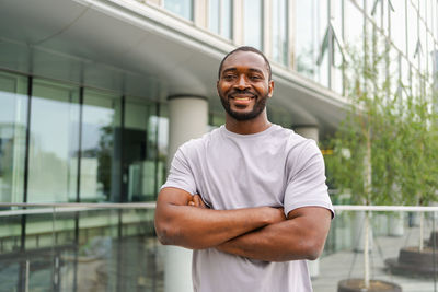 Portrait of young man standing against window