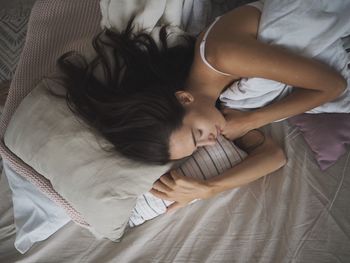 High angle view of woman sleeping on bed