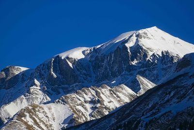 Scenic view of snowcapped mountains against clear blue sky