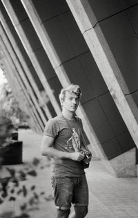 Low angle view of man with a photo camera standing against wall