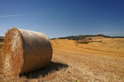 Hay bales on field against sky