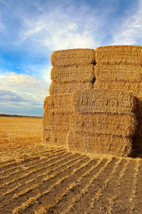 Hay bales on field against sky