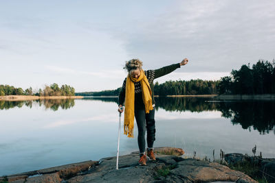 Man standing by lake against sky