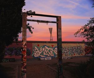 Graffiti on wall against sky during sunset