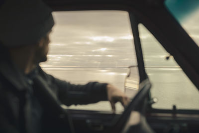 Man looking at sea while sitting in motor home